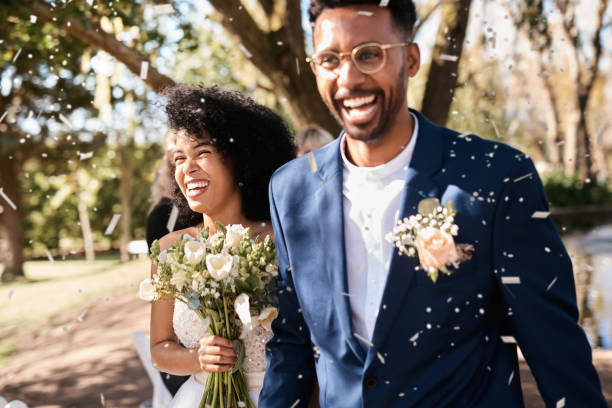 Joyful newlywed couple walking through confetti